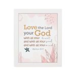 Love the Lord your God with all your heart, soul, and mind Matthew 22:37 Bible Wall Art with golden and black text, pastel pink abstract patterns, and leaf accents, displayed on the wall in a white frame in a white background