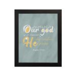 Christian wall art with Psalm 115:3 verse in gold and white text, set against a light sage green background, with elegant script fonts. hung on the wall in a black frame