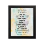 Fruit of the Spirit Bible verse wall art with black text and pastel watercolor background, Galatians 5:22-23. hung on the wall in a black frame