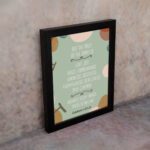 Christian wall art with Galatians 5:22-23 Bible verse on a light green background with light pink, brown, and green leaf design and black frame on the wall.