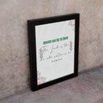 Psalm 54:4 Bible verse wall art with floral accents, green and red text, and a white background. displayed on the wall in a black frame