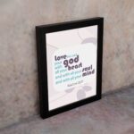 Love the Lord your God with all your heart, soul, and mind Matthew 22:37 Bible Wall Art with purple and teal text, abstract shapes, and leaf motifs on light cream background displayed on the wall in a black frame