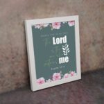 Surely God is my help Psalm 54:4 Bible verse wall art with bold and cursive fonts, floral accents, and a dark green background. displayed on the wall in a white frame