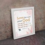 Love the Lord your God with all your heart, soul, and mind Matthew 22:37 Bible Wall Art with golden and black text, pastel pink abstract patterns, and leaf accents, displayed on the wall in a white frame