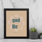 Psalm 115:3 Bible verse wall art with bold teal and orange text, blue highlights, and a soft beige background with a floral accent. displayed on the wall in a black frame