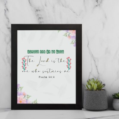 Psalm 54:4 Bible verse wall art with floral accents, green and red text, and a white background. displayed on the wall in a black frame