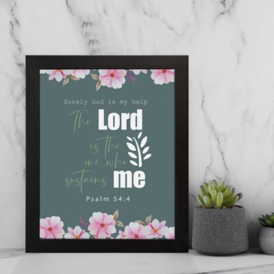 Surely God is my help Psalm 54:4 Bible verse wall art with bold and cursive fonts, floral accents, and a dark green background. displayed on the wall in a black frame