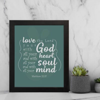 Love the Lord your God with all your heart, soul, and mind Matthew 22:37 Bible Wall Art with a white script font on a deep teal background, minimalistic design displayed on the wall in a black frame