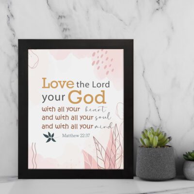 Love the Lord your God with all your heart, soul, and mind Matthew 22:37 Bible Wall Art with golden and black text, pastel pink abstract patterns, and leaf accents, displayed on the wall in a black frame