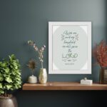 Christian wall art featuring Joshua 24:15 Bible verse on a gray and white background with gray design and green font and brown framed hung on the table