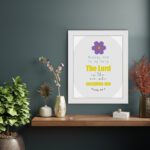 Psalm 54:4 Bible verse wall art with bold yellow text, purple flower, and light grey circular background pattern. displayed on the wall in a white frame