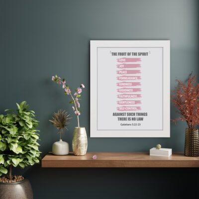 Bible wall art displaying The Fruit of the Spirit verse from Galatians 5:22-23 with pink brushstrokes on a white background. displayed on the wall in a white frame