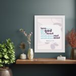 Love the Lord your God with all your heart, soul, and mind Matthew 22:37 Bible Wall Art with purple and teal text, abstract shapes, and leaf motifs on light cream background hung on the wall in a black frame