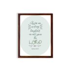 Christian wall art featuring Joshua 24:15 Bible verse on a gray and white background with gray design and green font and brown framed hung on the wall