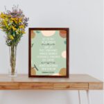 Christian wall art with Galatians 5:22-23 Bible verse on a light green background with light pink, brown, and green leaf design and brown frame table on the wall