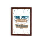 Bible wall art featuring The Lord Is My Rock, My Fortress, and My Deliverer in blue and tan text on a white background with decorative lines. hung on the wall in a brown frame