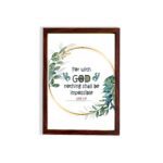 Wall art featuring the quote With God Nothing Shall Be Impossible from Luke 1:37, surrounded by a golden frame and green leaves. hung on the wall in a brown frame