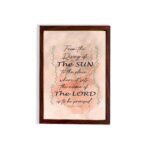 Bible wall art featuring Psalm 113:3 with floral elements and stylish text on a peach background. hung on the wall in a brown frame