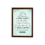 Wall art displaying Psalm 113:3 with elegant cursive font and leafy motifs on a mint green background. hung on the wall in a brown frame