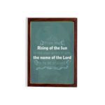 Wall art displaying Psalm 113:3, featuring white text on a dark green background with butterfly and leaf designs. hung on the wall in a brown frame