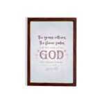 Christian wall art with the verse The Grass Withers, The Flower Fades But The Word Of Our God Will Stand Forever Isaiah 40:8. hung on the wall in a brown frame