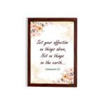 Infidu Bible wall art with Colossians 3:2 in dark brown text, surrounded by peach and beige flowers on a cream background. hung on the wall in a brown frame