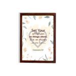 Colossians 3:2 Bible verse wall art with floral design and bold lettering, featuring the words Set Your Affection on Things Above. hung on the wall in a brown frame