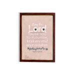 Christian wall art featuring Psalm 115:14, with large text, floral decorations, and a warm beige background. hung on the wall in a brown frame