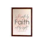 Christian wall art displaying the quote We Walk By Faith Not By Sight in elegant fonts on a soft beige-pink background. hung on the wall in a brown frame