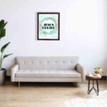 Infidu Jesus Christ Bible Wall Art with JESUS CHRIST text in a mint blue background surrounded by a floral wreath. displayed on the wall in a brown frame