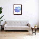 Bible wall art with The Lord Is My Rock, My Fortress, and My Deliverer in white stencil-style text on a blue watercolor background. hung on the wall in a displayed brown frame