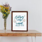 Proverbs 4:7 Christian wall art with elegant script and floral design, featuring Getting Wisdom Is The Wisest Thing You Can Do. displayed on the table in a brown frame