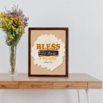 Infidu Bless The Lord O My Soul Psalm 103:1 Christian wall art featuring orange and black text on a beige background. displayed on the table in a brown frame