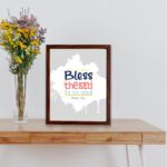 Bless The Lord O My Soul Psalm 103:1 Christian wall art in bold blue and orange, with a light gray background and splash design. displayed on the table in a brown frame