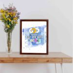 God Is Within Her She Will Not Fall Psalm 46:5 Bible Verse Wall Art with bright colors and watercolor background displayed on the table in a brown frame