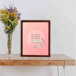 And Everyone Who Calls On The Name Of The Lord Will Be Saved Acts 2:21 Bible Verse Wall Art with pink flowers and soft pink background. displayed on the table in a brown frame