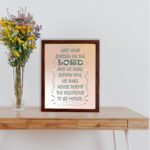 Cast Your Burden on the Lord Psalm 55:22 Bible verse wall art with teal lettering and soft peach background, Christian home decor. displayed on the table in a brown frame