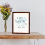 Christian wall art featuring the phrase I Still Remember The Days I Prayed For What I Have Now with floral designs in light blue. displayed on the table in a brown frame