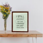 Christian wall art with the phrase I Still Remember The Days I Prayed For What I Have Now on a light green background. displayed on the table in a brown frame