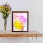 Christian wall art with Psalm 63:3, bold text in playful font, vibrant yellow, pink, and purple gradient on a warm background with a black frame. displayed on the table in a brown frame