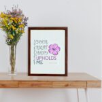 Your Right Hand Upholds Me Psalm 63:8 Christian Wall Art with bold text and floral design on a mint green background. displayed on the table in a brown frame