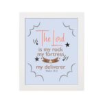 The Lord Is My Rock My Fortress And My Deliverer Psalm 18:2 Bible Wall Art with red, brown, and black text on a light blue background. hung on the wall in a white frame