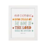 Bible wall art with Acts 2:21 verse, featuring pastel polka dots and bold text, designed to inspire and uplift your home decor. hung on the wall in a white frame