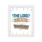 Bible wall art featuring The Lord Is My Rock, My Fortress, and My Deliverer in blue and tan text on a white background with decorative lines. hung on the wall in a white frame