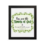 You Are The Temple Of God, His Spirit Dwells In You 1 Corinthians 3:16 Bible Verse Wall Art with green leaf wreath design. hung on the wall in a black frame