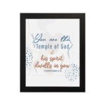 Christian wall art with You are the Temple of God in blue calligraphy and decorative blue dot patterns on a white background. hung on the wall in a black frame