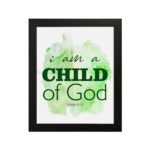 I Am A Child Of God wall art in elegant fonts with a green and black color scheme on a soft green watercolor background. hung on the wall in a black frame