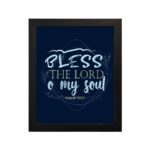 Infidu wall art featuring Bless The Lord O My Soul Psalm 103:1 in gold and white text on a dark blue background with decorative leaves. hung on the wall in a black frame