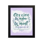 Christian wall art with Getting Wisdom Is The Wisest Thing You Can Do Proverbs 4:7, green text, light purple background, and decorative swirls. hung on the wall in a black frame