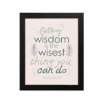 Infidu wall art with Proverbs 4:7 text surrounded by green leaves on a beige background. Elegant and minimal design. hung on the wall in a black frame